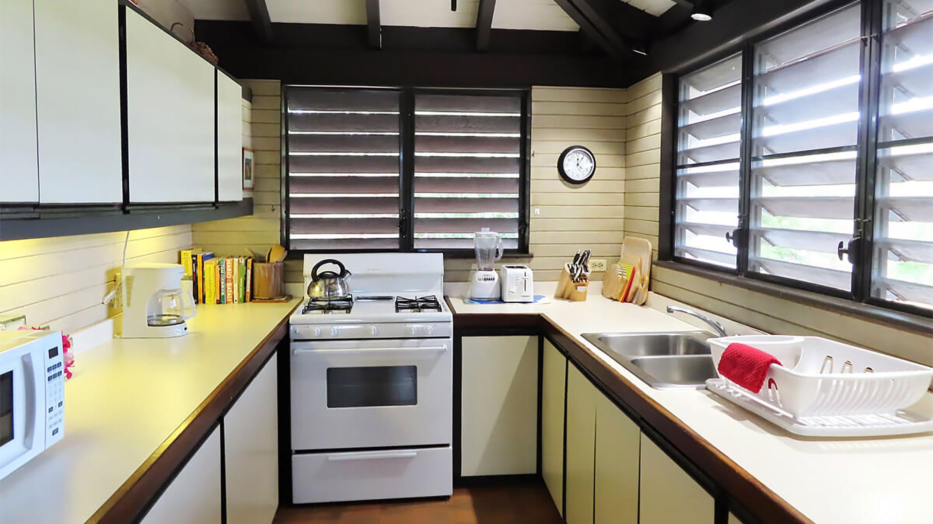 A Kitchen With A Stove Top Oven Sitting Next To A Window