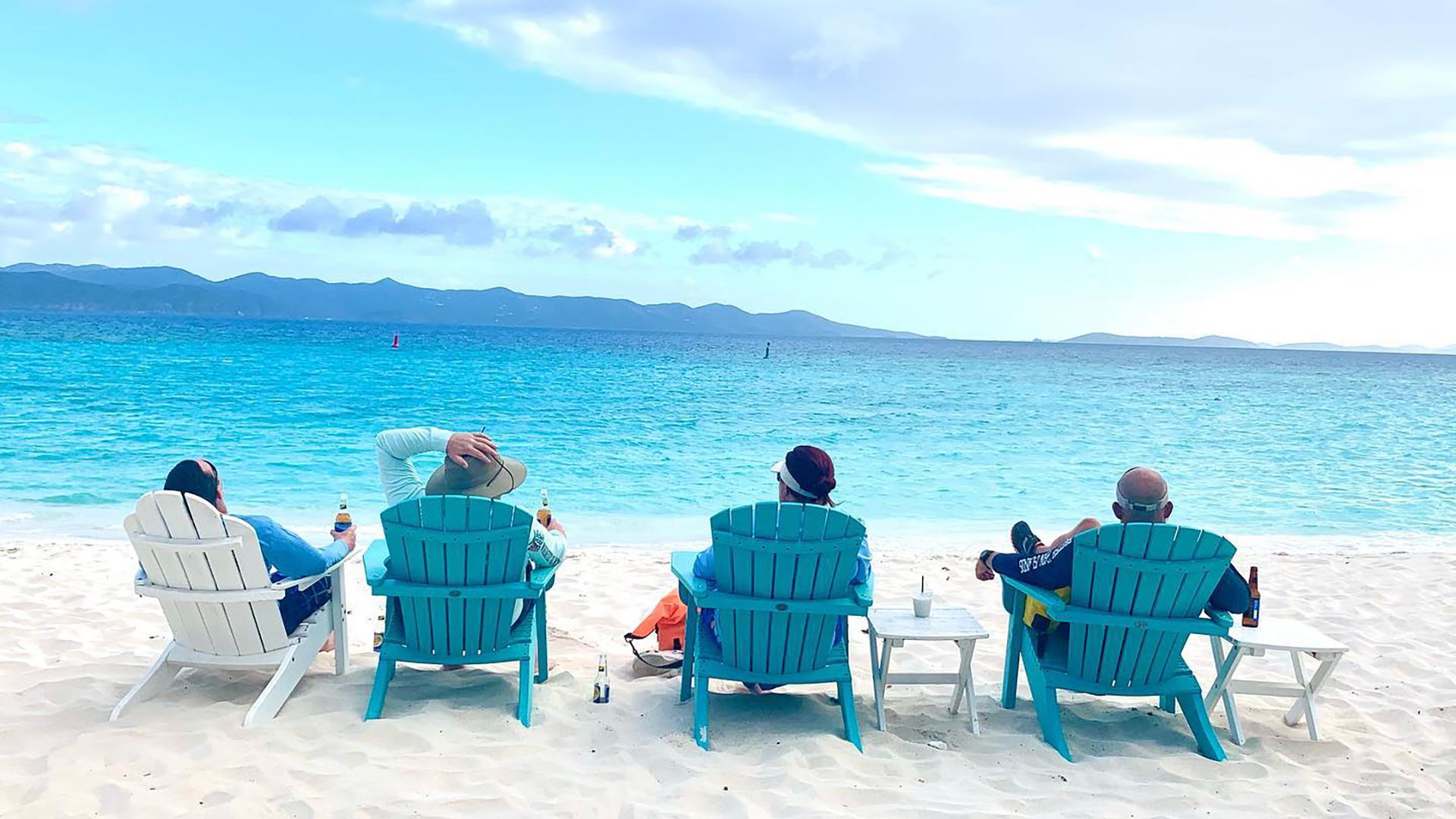 A Group Of People Sitting At A Beach